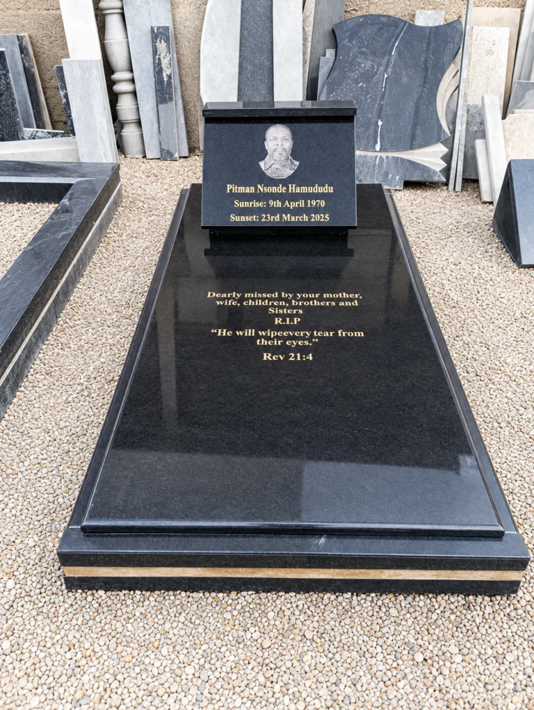 Inclined black granite plaque with an engraved portrait and gold lettering, on a long ledger with a gold inscription