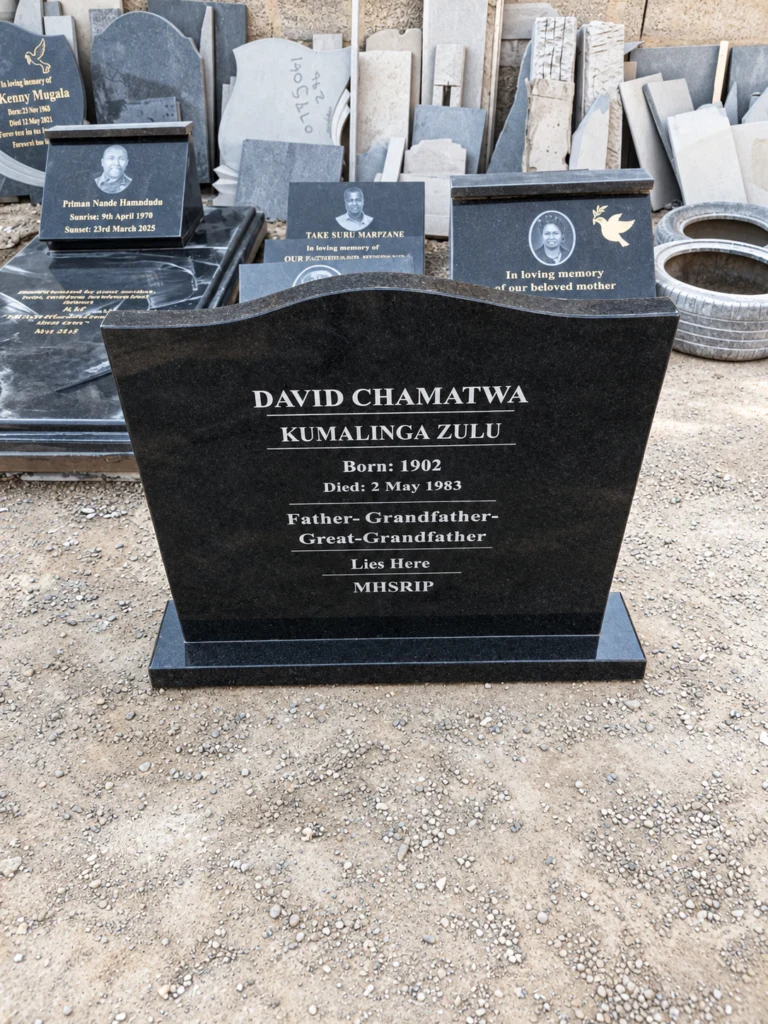 Black granite headstone with a curved top, white engraved lettering and fine dividing lines